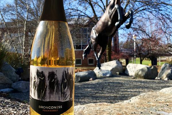 Bronconess Peach Wine in front of a Bronco Statue