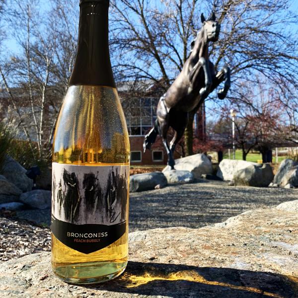 Bronconess Peach Wine in front of a Bronco Statue